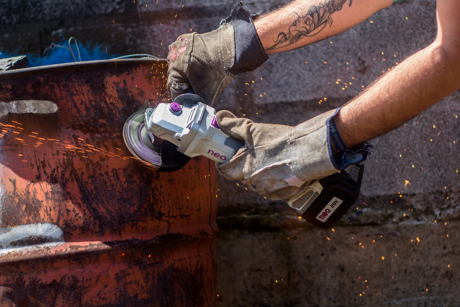 Fabricator stripping paint and rust from a steel panel with a clean and strip disc on an angle grinder