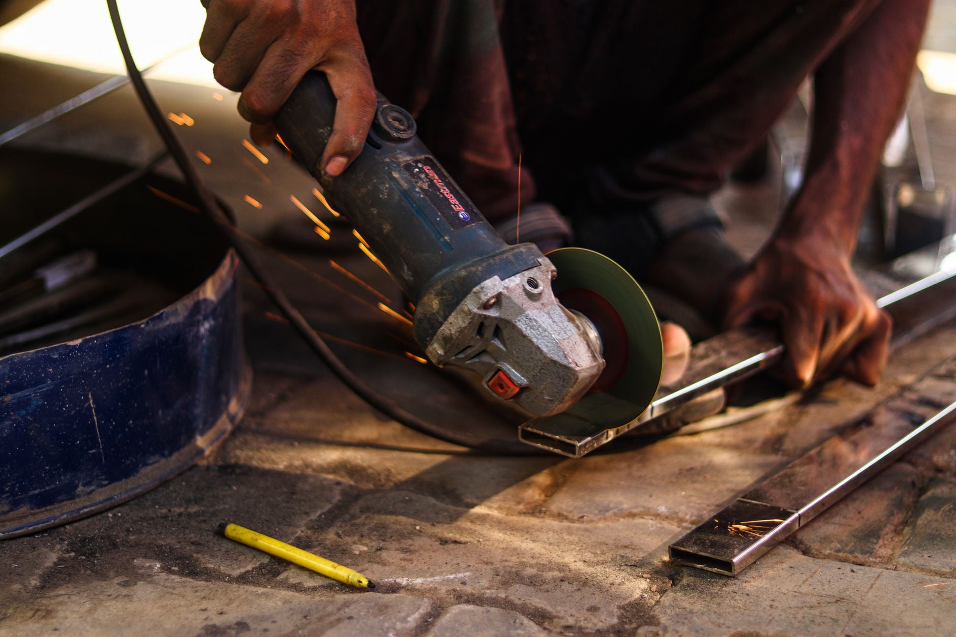 Angle grinder with a cut-off disc mounted, wheel guard covering the top half of the disc