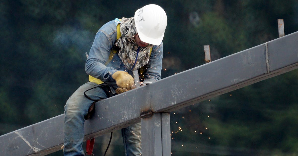 Welder working on a structural steel beam — heavy fabrication, Ontario
