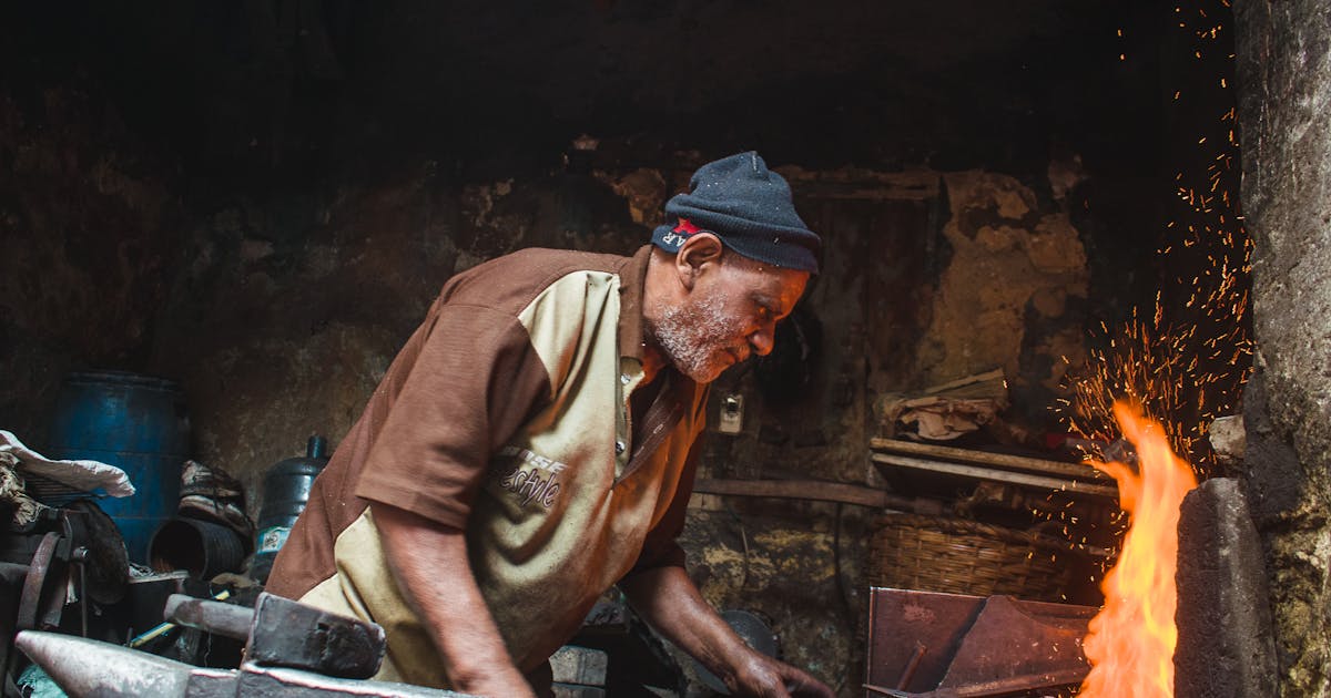 Metalworker deburring and finishing a steel edge in an Ontario fabrication shop