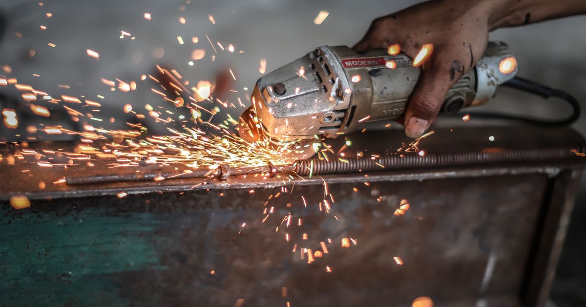 Close-up of a metalworker grinding steel with sparks flying — aluminum oxide vs silicon carbide, Whitby Abrasives, Ontario, Canada