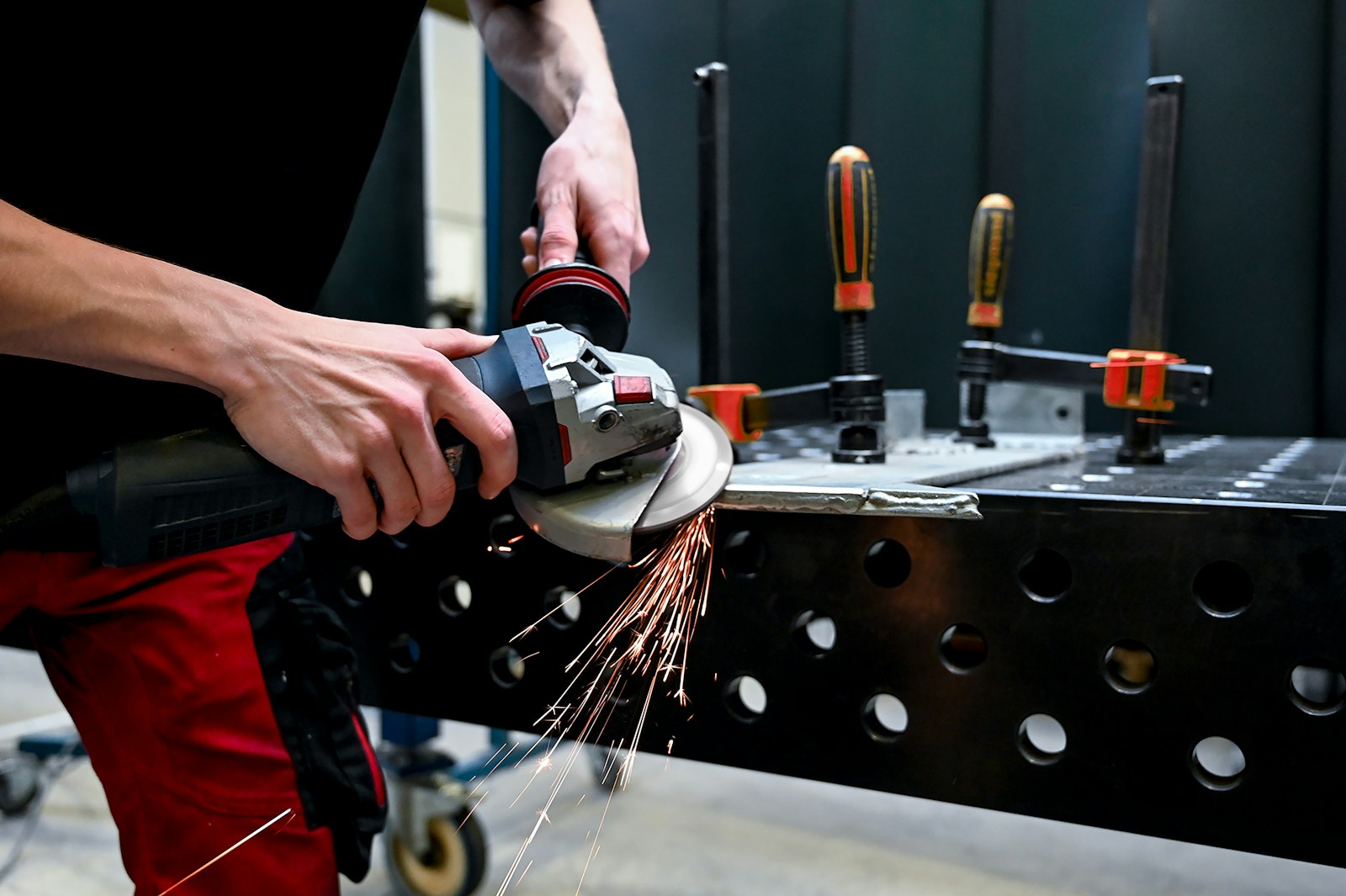 Close-up of an angle grinder cutting a piece of metal — flap disc and grinding wheel abrasives in action