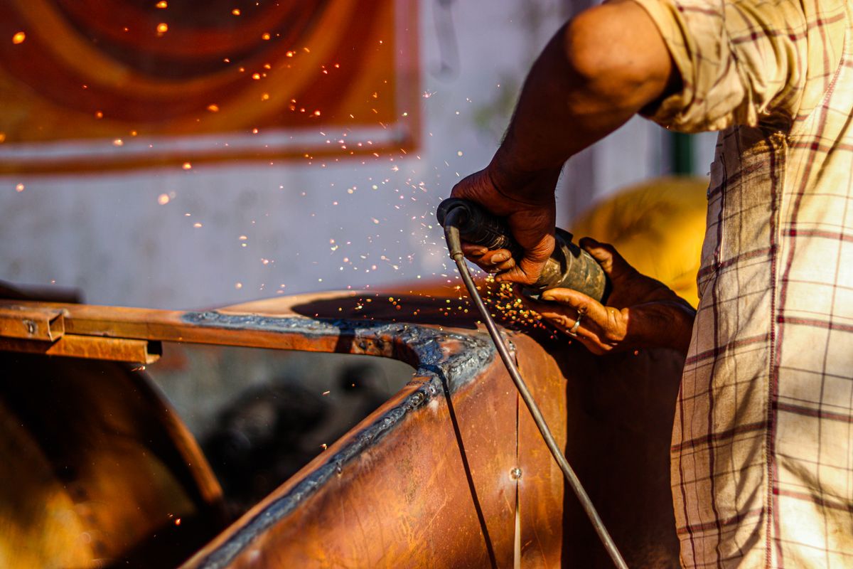 Close-up of an angle grinder and abrasive disc cutting metal with sparks — ceramic abrasive technology