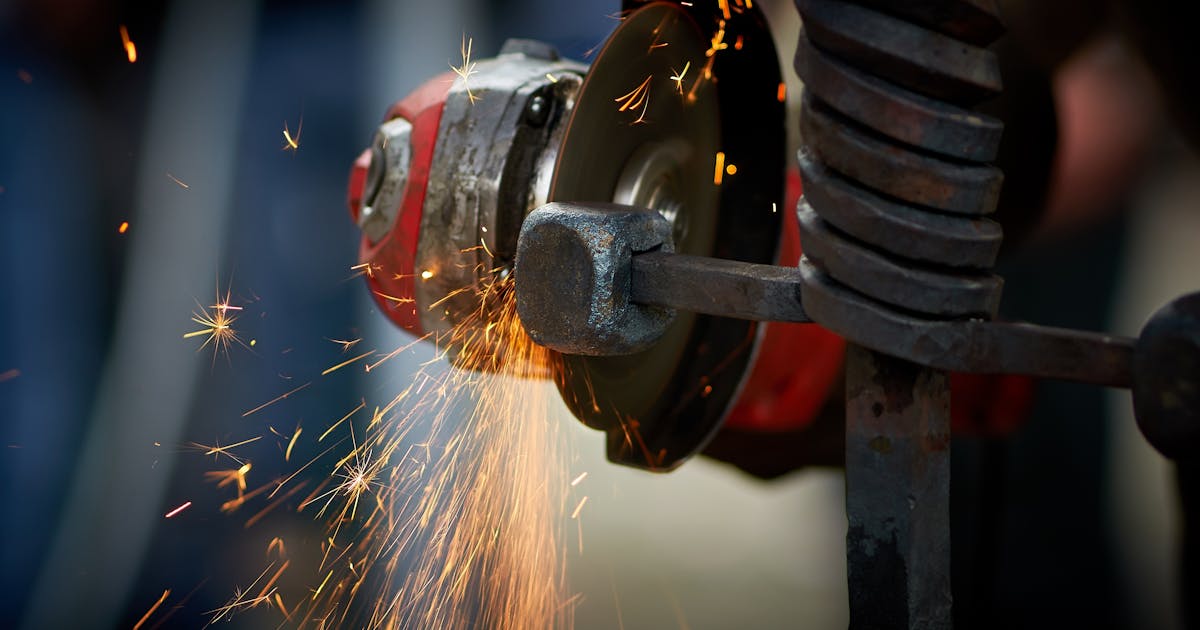 Angle grinder shaping steel with sparks — Whitby Abrasives flap discs, Ontario