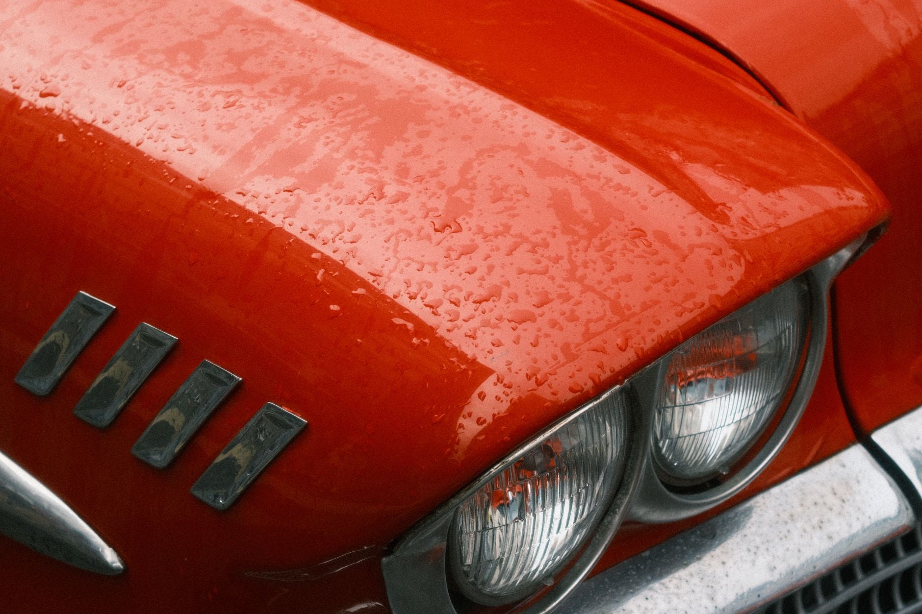 Hand wet sanding a clearcoated car panel with fine waterproof sandpaper and water