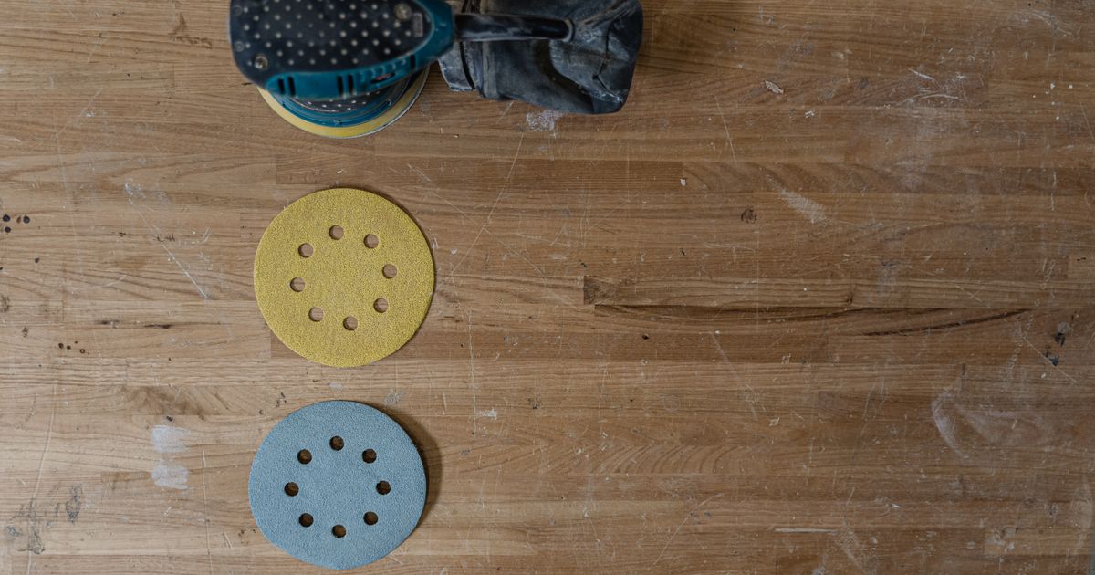 An electric sander and sandpaper grit discs on a workshop bench — fepa vs cami grit, Whitby Abrasives, Ontario, Canada