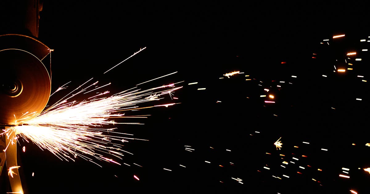 Angle grinder removing a weld with sparks on steel — Whitby Abrasives, Ontario