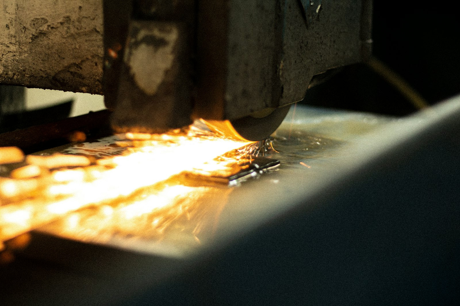 Sparks flying as a worker grinds metal with an abrasive disc